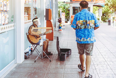 Rear view of people playing on tiled floor