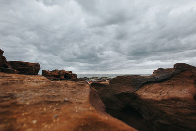Rock formations on sea shore against sky