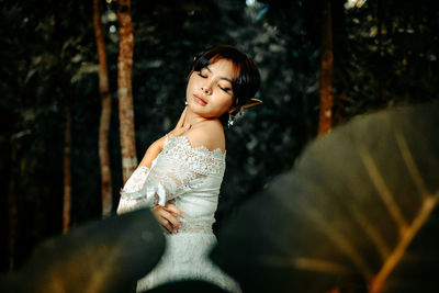 Side view of young woman sitting outdoors