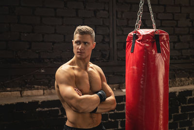 Portrait of shirtless man exercising in gym