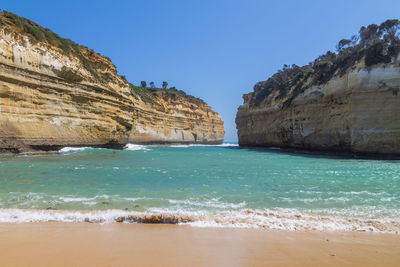 Scenic view of beach against clear blue sky