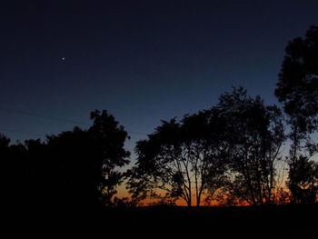 Silhouette trees against sky during sunset