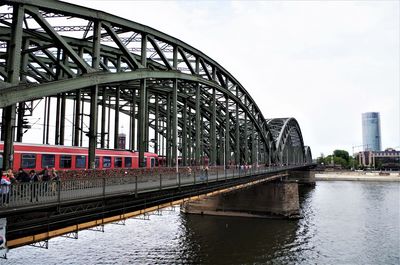 Bridge over river in city against sky