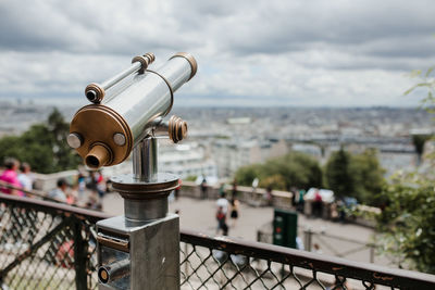 Close-up of coin-operated binoculars against cityscape