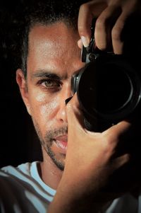 Close-up portrait of young man holding sunglasses