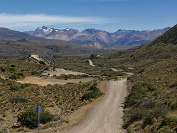 Road leading towards mountains against sky