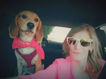 Smiling woman with dog in car