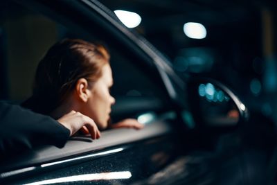 Side view of woman sitting in car