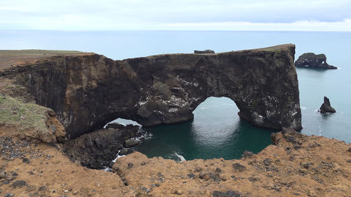 Rock formations by sea against sky