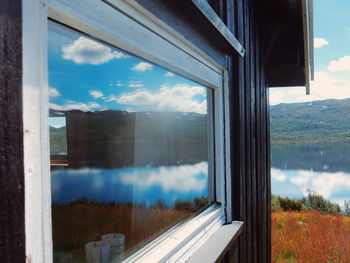 Reflection of mountain and lake on house window