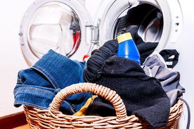 Close-up of person inserting clothes in washing machine