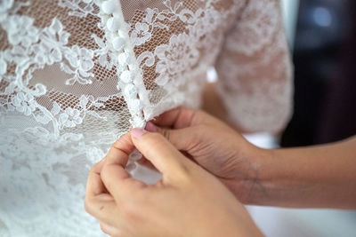 Cropped hand holding zipper of bride