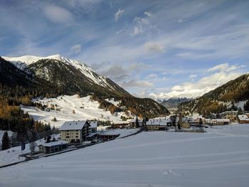 Houses on snowcapped mountain against sky