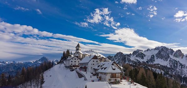 Panoramic view of buildings and snowcapped mountains against sky