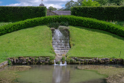 Long exposure of a waterfall flowing down stairs in an ornamental garden