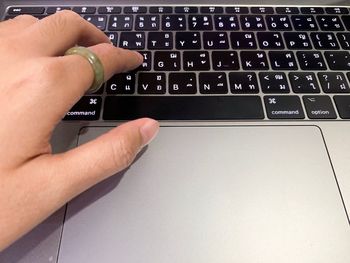 Cropped image of person using laptop