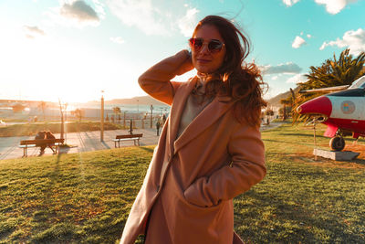 Portrait of woman wearing sunglasses standing on land against sky