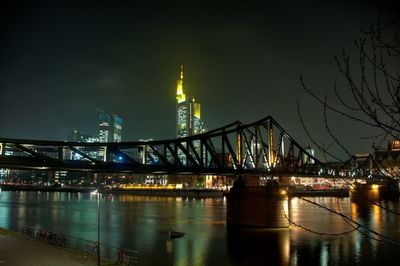 Illuminated bridge over river at night