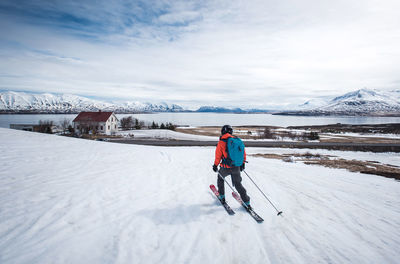 Woman skiing towards the ocean in iceland