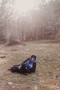 Side view of young man on field in forest