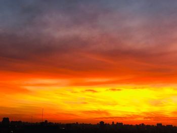 Silhouette landscape against dramatic sky during sunset