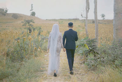 Rear view of woman standing on field