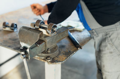 Close-up of man working on metal chain