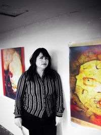 Portrait of young woman standing against wall