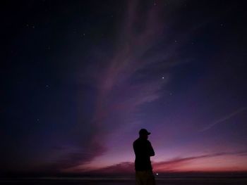 Silhouette man standing against sky at dusk