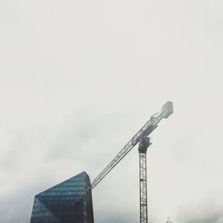 Low angle view of crane against sky