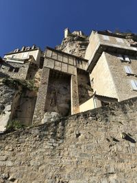 Low angle view of old building against clear blue sky