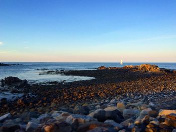 View of calm beach against clear sky