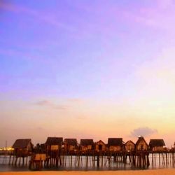 Built structures against sky at sunset