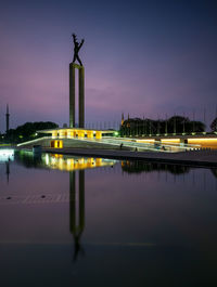Statue of illuminated city at night