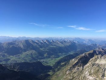 Scenic view of mountains against blue sky