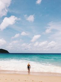 Full length of woman on beach against sky