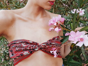 Close-up of woman standing by pink flowers