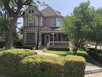 Trees and house in lawn against sky