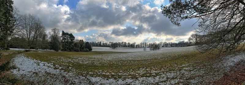 Panoramic shot of snow covered field against sky