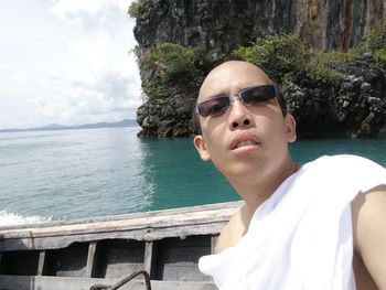 Portrait of man wearing eyeglasses against sea