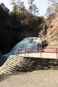Built structure by river against trees in forest