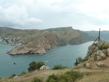 Scenic view of sea and mountains against sky