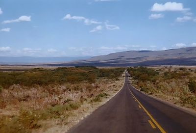 Empty road along landscape against sky