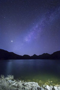 Scenic view of lake against sky at night