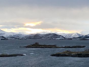 Scenic view of sea and mountains against sky during sunset