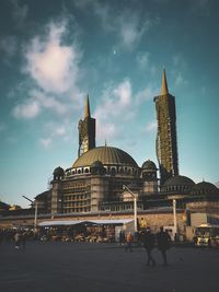 New mosque at taksim square against cloudy sky and half the moon in istanbul