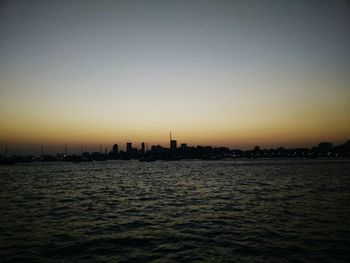 View of city at waterfront during sunset