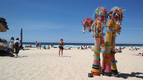 People at beach against sky