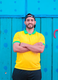 Portrait of young man standing against wall