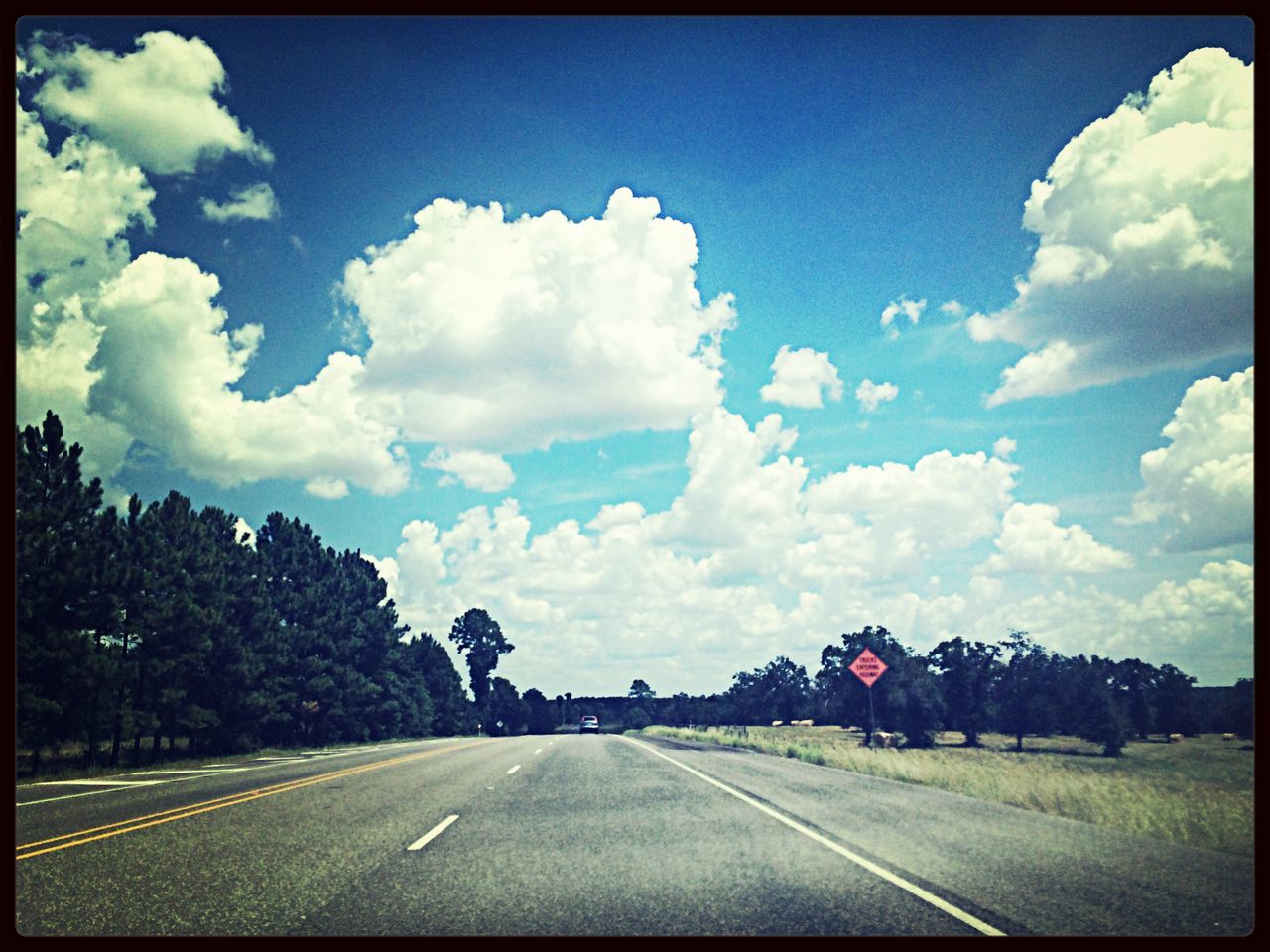 road, transportation, transfer print, sky, the way forward, road marking, cloud - sky, diminishing perspective, country road, auto post production filter, cloud, vanishing point, landscape, tree, empty, cloudy, blue, street, tranquility, tranquil scene